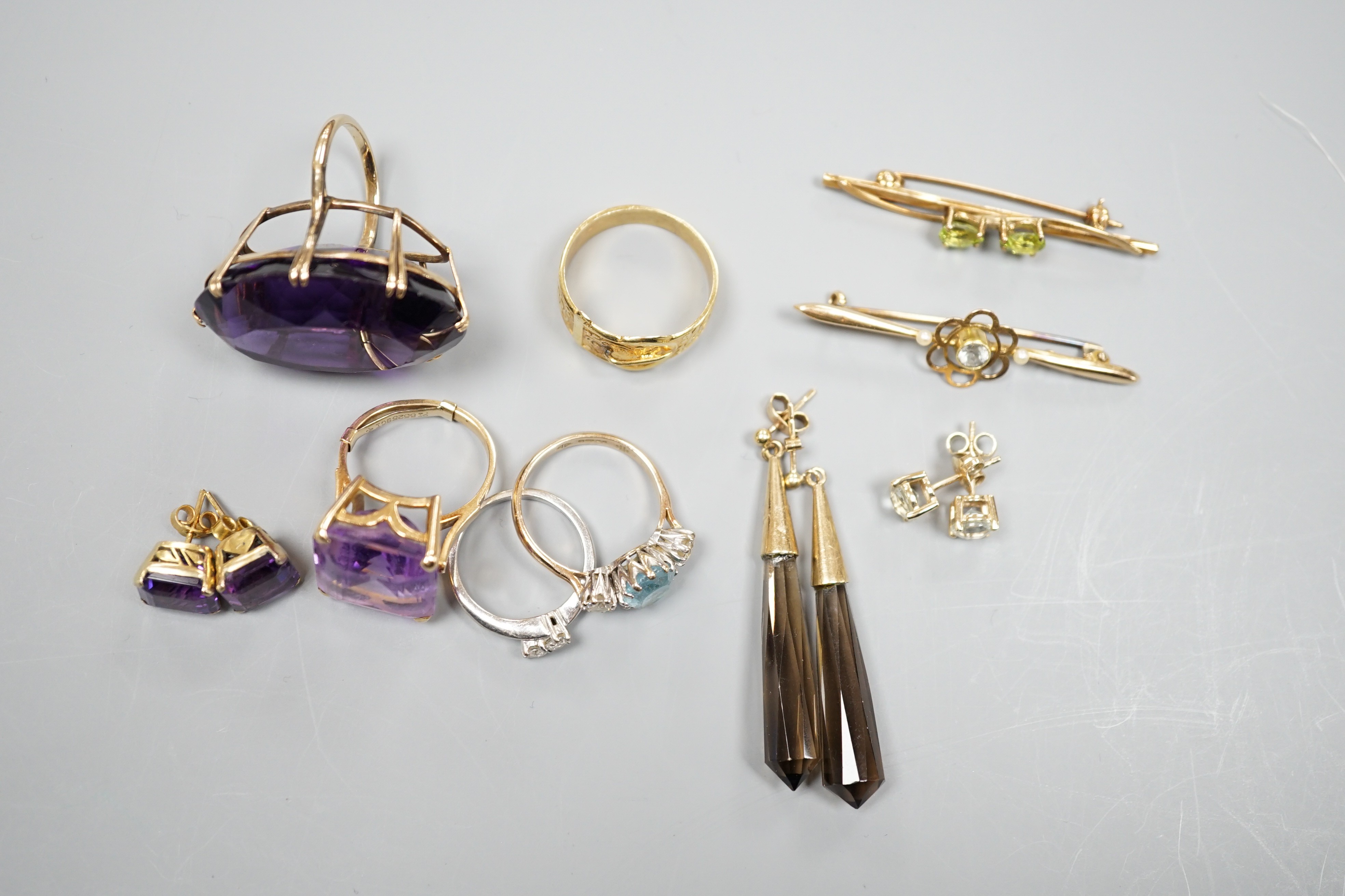 A large 9ct and oval cut amethyst dress ring, size L, three other rings including a 9ct gold buckle ring, an 18ct white gold and two stone crossover ring, two gem set bar brooches including 15ct and three assorted pairs